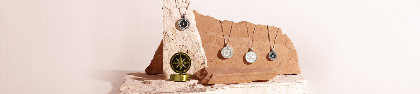 handmade traveling pendants and traveling talisman displayed on strong, beautiful rock