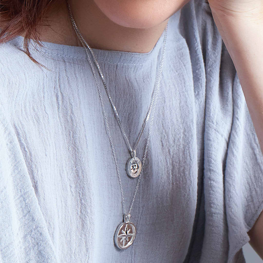 woman wearing two sterling silver pendants